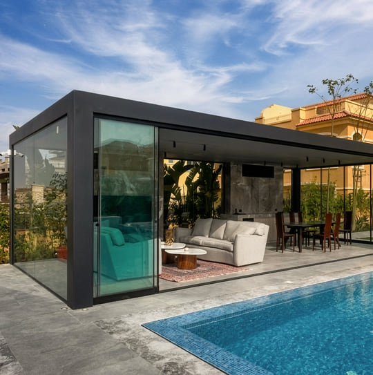 Pergola bioclimatique fermée par des parois vitrées coulissantes au bord d'une piscine à Tanger — Aluminium Tanger